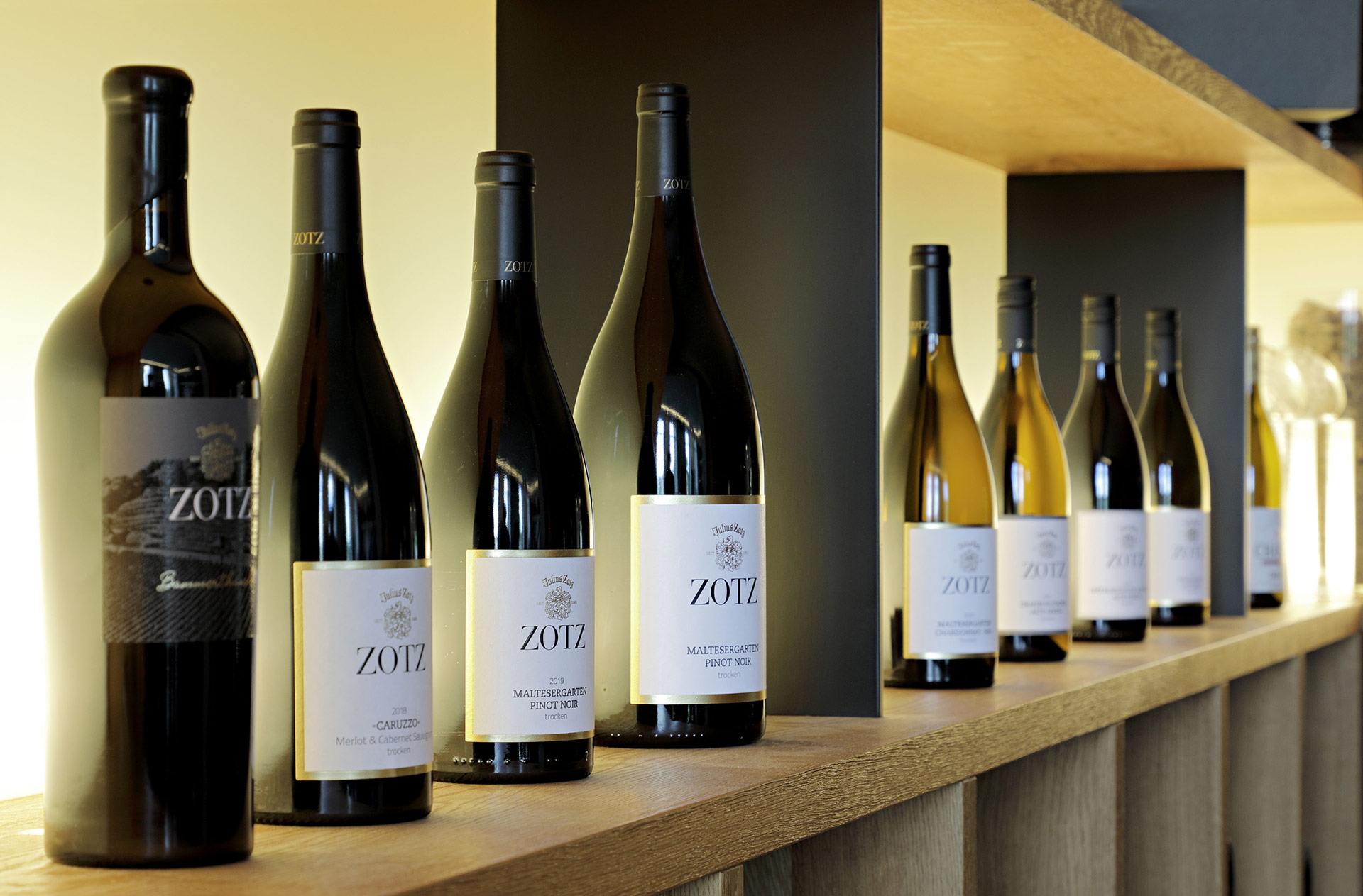 Weinregal voller Weinflaschen mit Etikett von Weingut Zotz in der Vinothek